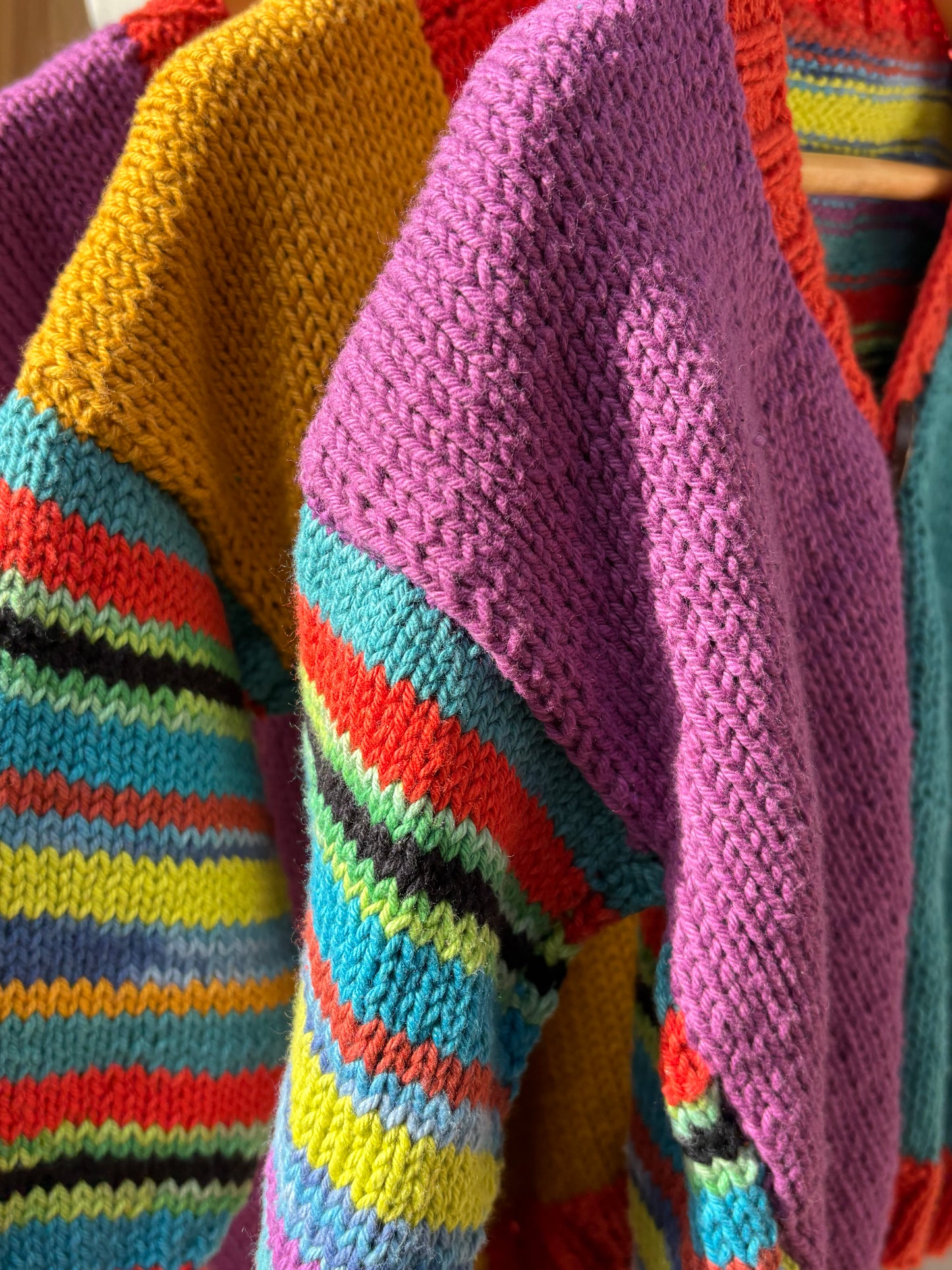 Colorful knitted sweaters in various patterns and colors.